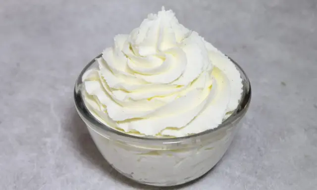 Chantilly au robot pâtissier, aérienne et onctueuse, dressée en rosace dans un bol en verre. Parfait pour garnir vos desserts.