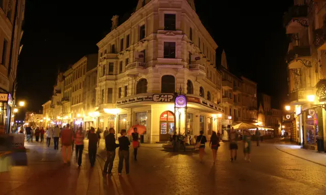 Wieczorny spacer po Rynku w Toruniu, gdzie liczne atrakcje kuszą przechodniów.