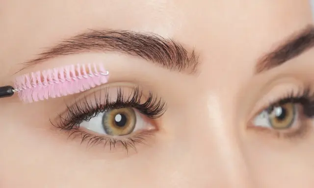 Brosse à cils rose peignant des cils longs et épais. Attention aux dangers de l'huile de ricin pour les cils.