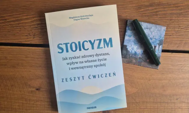 Zeszyt ćwiczeń "Stoicyzm. Jak zyskać zdrowy dystans, wpływ na własne życie i wewnętrzny spokój" obok zielonego pióra. Sztuka życia według stoików.
