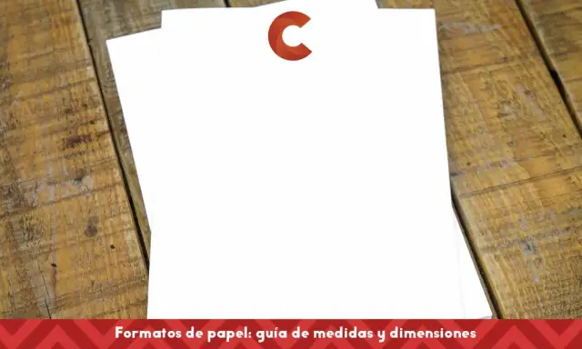 Dos hojas de papel blanco apiladas sobre una mesa de madera rústica. El papel para flyers está listo para ser diseñado.