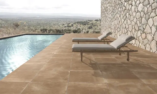 Elegante suelo para piscinas de tonos tierra, con tumbonas y vistas a un paisaje natural.