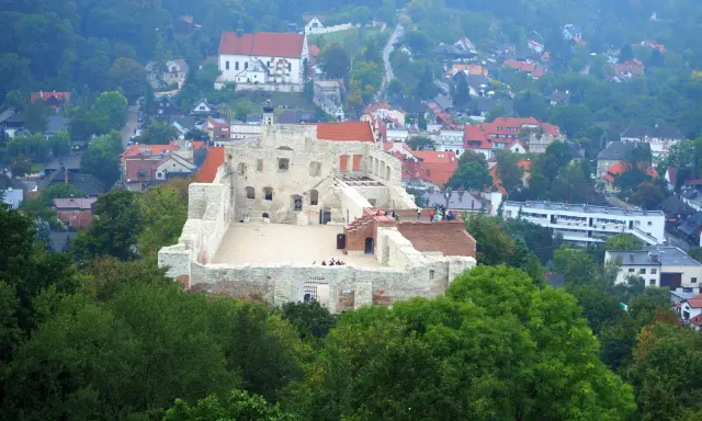 Ruiny zamku w Kazimierzu Dolnym, wspaniałe kazimierz dolny atrakcje dla dzieci. Widać ludzi zwiedzających, a w tle miasteczko.