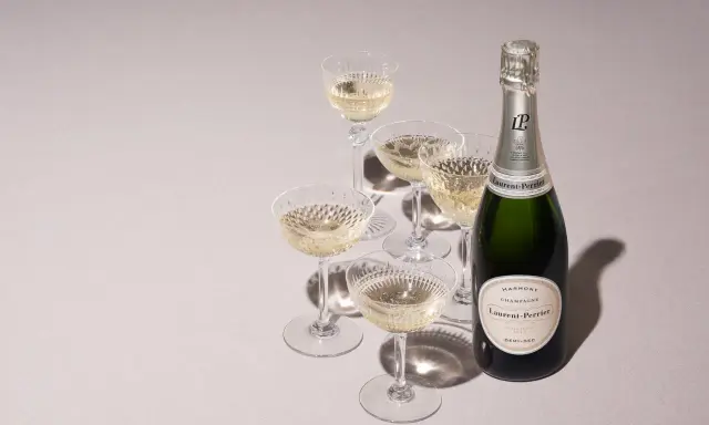 Flasche Laurent-Perrier Champagner neben gefüllten Gläsern. Ein süßer Champagner für besondere Anlässe.