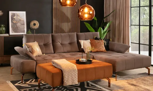 Elegancki salon z brązową sofą i pomarańczowym pufem. Kolor taupe z czym łączyć? Z miedzią, czernią i ciepłymi brązami.
