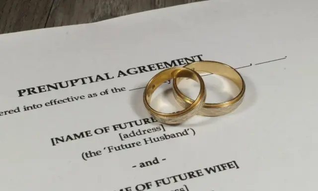 Złote obrączki na dokumencie "Prenuptial Agreement" – protokół przedmałżeński, który określa warunki przed ślubem.