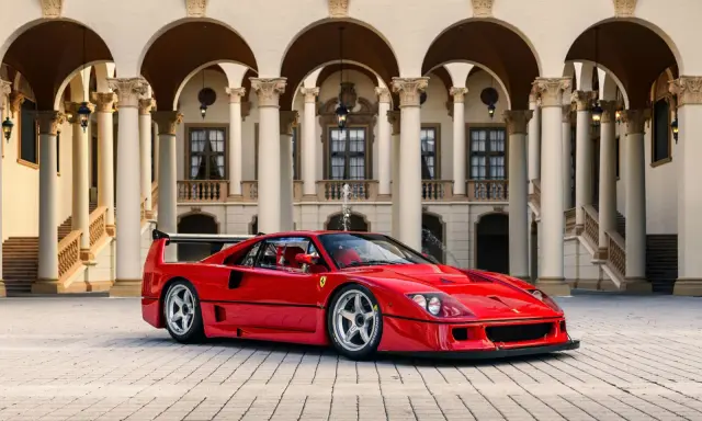 Ein roter Ferrari F40 steht vor einer prächtigen Villa mit Säulengängen.