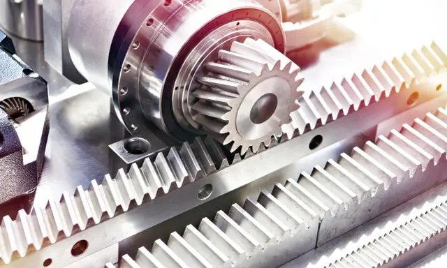Metalowe tryby i zębatki, tworzące mechanizm przekładni zębatej, gotowe do pracy.