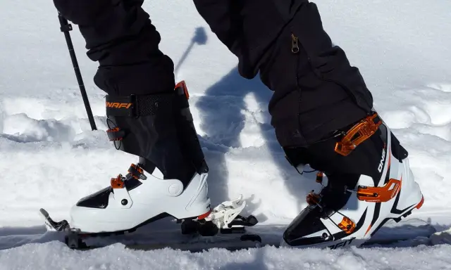 Skitury co to? Widok z perspektywy narciarza w butach i nartach skiturowych, gotowego do podboju ośnieżonych szlaków.