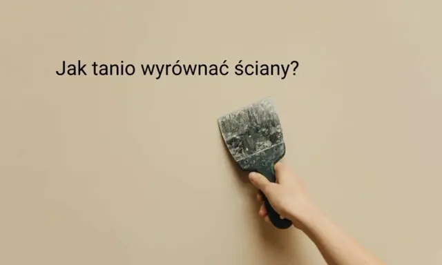 Ręka trzyma szpachelkę przy beżowej ścianie, szukając pomysłu na krzywe ściany.