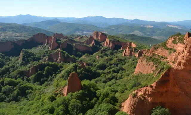 Paisaje de Las Médulas, León. Impresionantes formaciones rojizas y vegetación exuberante, ideal para rutas senderismo León.