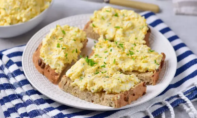Pyszna pasta z jajek na chlebie, posypana szczypiorkiem i pieprzem. Idealna na szybkie śniadanie lub przekąskę.