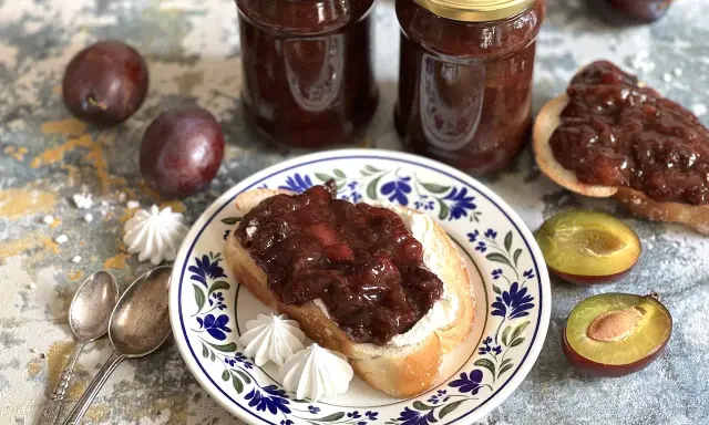 Słoiki pełne domowych powideł z piekarnika, na talerzu kromka chleba z tym pysznym smarowidłem.