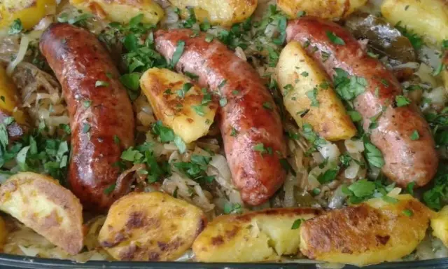 Pyszna biała kiełbasa z kapustą kiszoną i pieczonymi ziemniakami, posypana natką pietruszki.