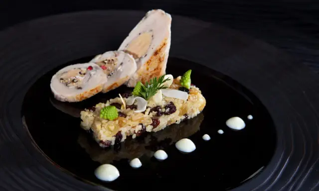 Un roulé de volaille farci au foie gras, accompagné d'un riz aux fruits secs et légumes verts, une spécialité Jura.