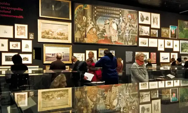 Wystawa w Krakowie, gdzie można podziwiać obrazy i rzeźby. Wiele osób zwiedza ekspozycję, ciesząc się darmowymi muzeami.