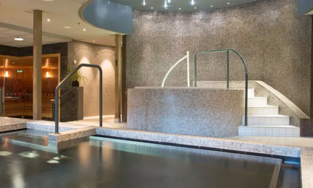 Avslappnande poolområde med bastu och trappa ner till vattnet på Lindvallen Skilodge.
