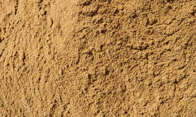Textura de arena de miga, ideal para construcción, jardinería y filtración. Sus usos son variados y esenciales.