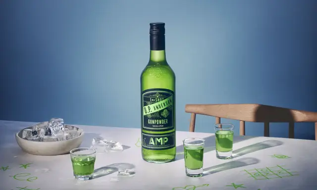 O.P. Anderson Gunpowder i gröna shotglas på ett bord med is och tic-tac-toe-ritningar.