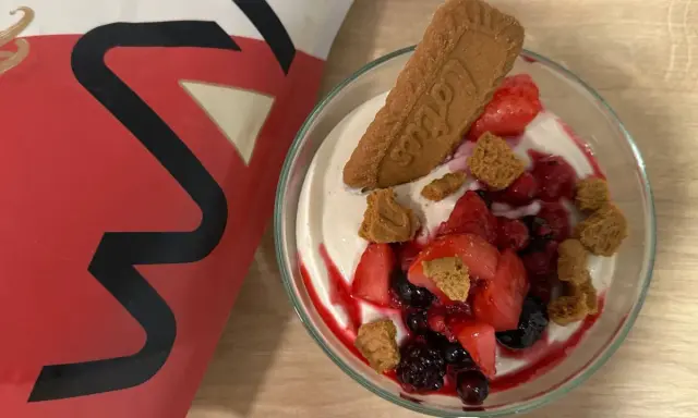 Leckere vegane Smoothie Bowl mit frischen Beeren, Kekskrümeln und einem Lotus-Keks.
