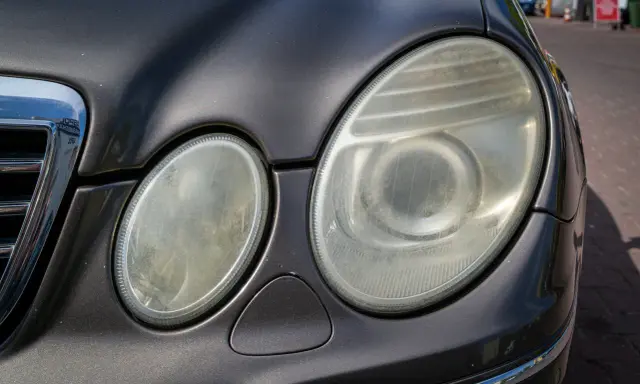 Zmatowiałe lampy samochodu, które wymagają polerowania. Zastanawiasz się, ile kosztuje polerowanie lamp?