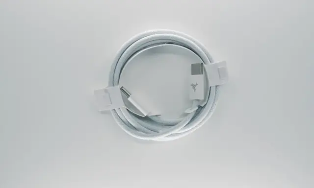 Biały kabel usb typu c, zwinięty w okrąg, z metalowymi końcówkami i logo producenta.
