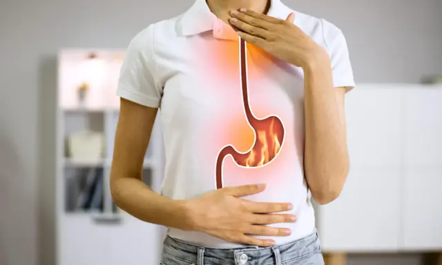 Persona con bruciore di stomaco, illustra la differenza tra pantoprazolo e omeprazolo per alleviare il disturbo.