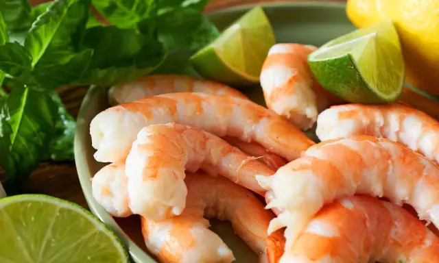 Garnelen schnell auftauen: Frische Garnelen mit Limette, Zitrone, Knoblauch und Basilikum für ein schnelles Auftauen und Zubereiten.