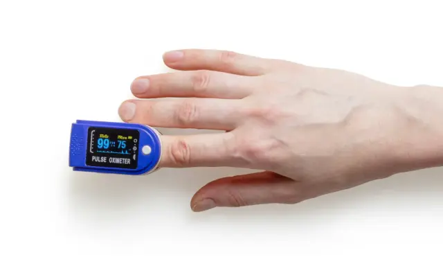 Fingerspitze mit Pulsoximeter, das den Puls beim Spazieren misst.