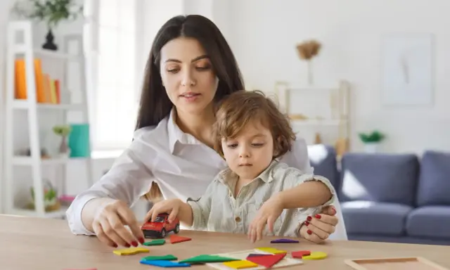 Mama i dziecko bawią się klockami. Zastanawiasz się, ile może zarobić dziecko, żeby nie stracić alimentów?