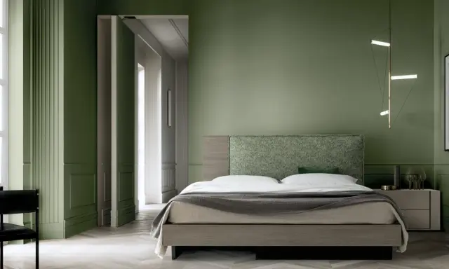 Camera da letto con pareti verde bosco, letto moderno con testiera tessuta e lampada geometrica.