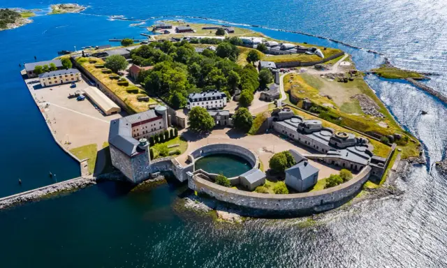 Överblicksbild av Karlsborgs fästning, en viktig del av Karlskrona historia, med sina befästningar, byggnader och omgivande vatten.