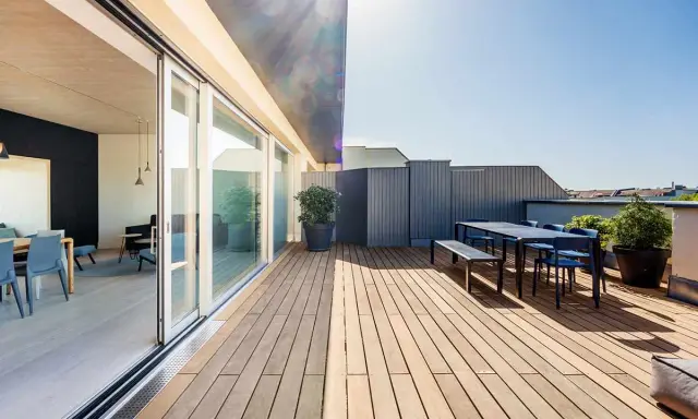 Modernes Einfamilienhaus mit großzügiger dachterrasse. Holzboden, Sitzgruppe und Pflanzen laden zum Verweilen ein.