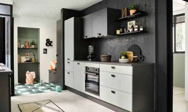 Cuisines vertes modernes avec murs texturés sombres, armoires claires et un coin bureau coloré.