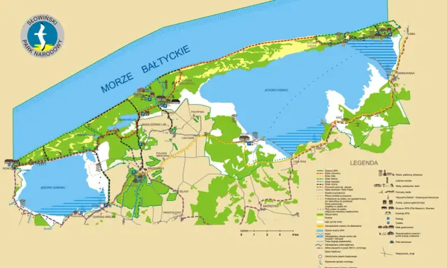 Mapa turystyczna Słowińskiego Parku Narodowego z zaznaczonymi szlakami, jeziorami, wydmami i miejscowościami.