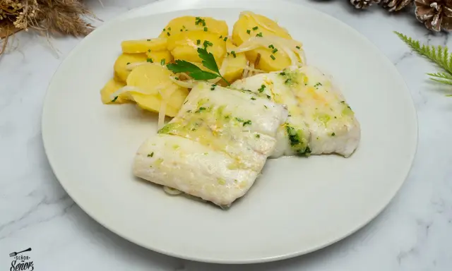 Deliciosa merluza al horno con patatas y cebolla, un plato principal perfecto para disfrutar de una comida casera.