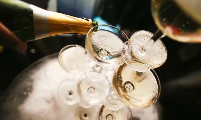 Champagner wird in Gläser gegossen, ein Moment, der die Champagner Geschichte feiert.