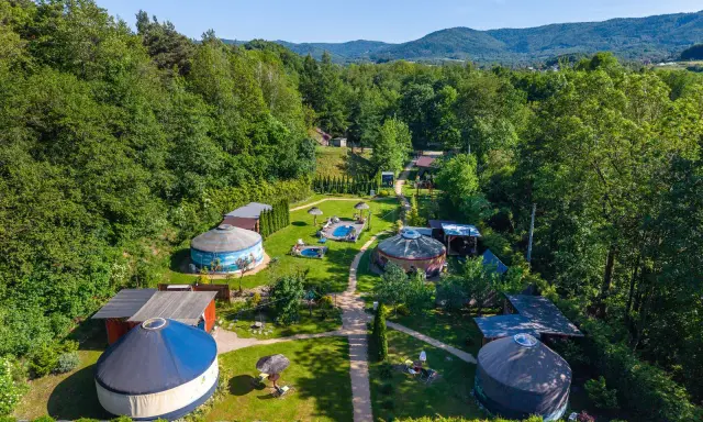Malowniczy aloha glamp z jurtami, basenami i zielonymi wzgórzami w tle. Idealne miejsce na relaks.