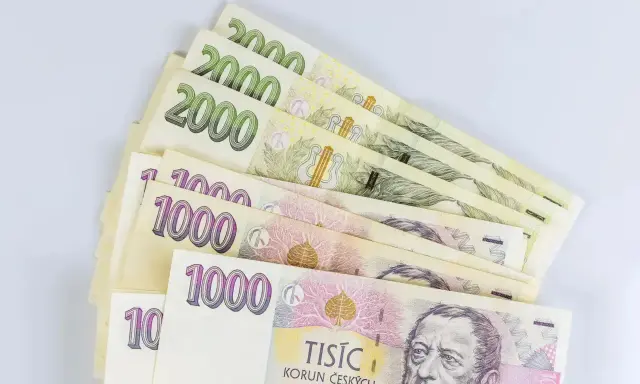 Kupka banknotów 1000 i 2000 koron czeskich, waluta w Czechach, leży na białym tle.