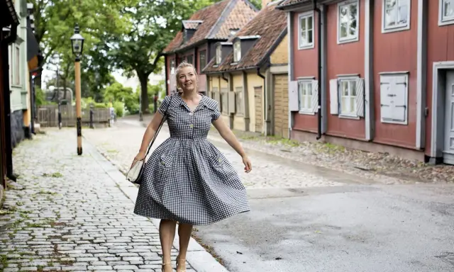 Kvinna i rutig klänning på kullerstensgata, inspirerad av Elsa Billgrens blogg.