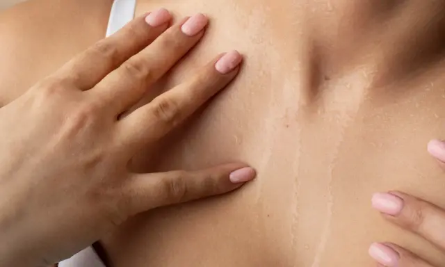 Mani accarezzano la pelle naturale cos'è: idratata e luminosa, con goccioline d'acqua che riflettono la luce.