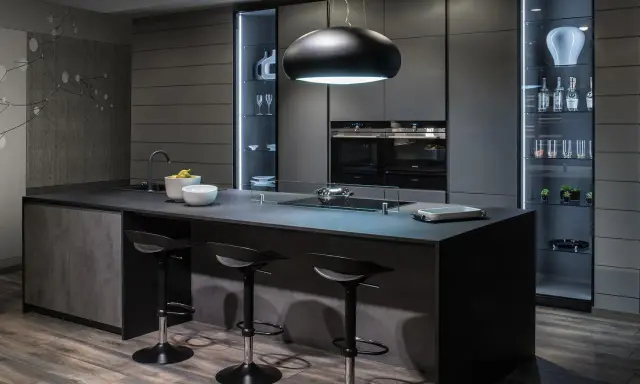 Cucina moderna con isola centrale e sgabelli. Il grigio scuro domina, creando un'atmosfera sofisticata. Perfetto per chi cerca idee su come abbinare il grigio scuro con stile.