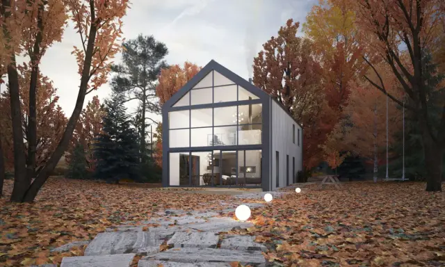 Maison moderne avec un grand pignon vitré, entourée d'arbres aux couleurs d'automne. Un chemin de dalles mène à la porte d'entrée.