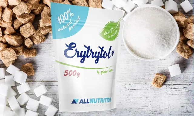 Erytrytol obok kostek cukru i miseczki z kryształkami. Naturalny słodzik, zdrowsza alternatywa dla cukru.