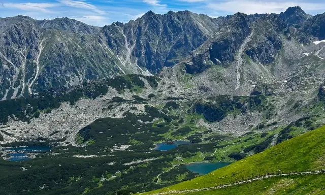 Tatry widziane z trasy turystycznej. Jeziora w dolinie, skaliste zbocza i zielone hale zachęcają do odkrywania piękna Zakopanego.