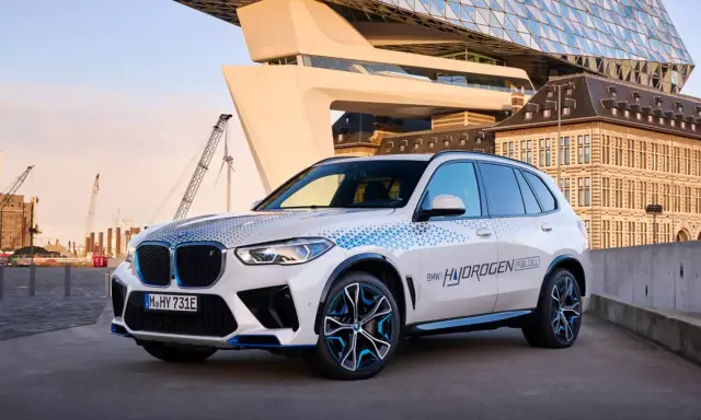 BMW iX5 Hydrogen, ein Vorreiter unter den BMW Elektro Modellen, mit futuristischer Architektur im Hintergrund.