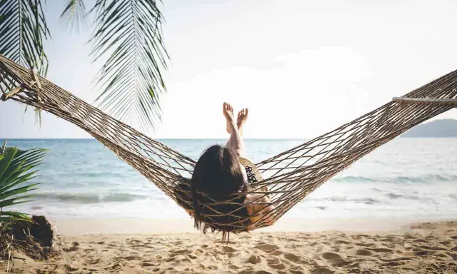 Relaks na plaży w hamaku, idealny opis wakacji po angielsku. Słońce, morze i palmy tworzą rajski widok.