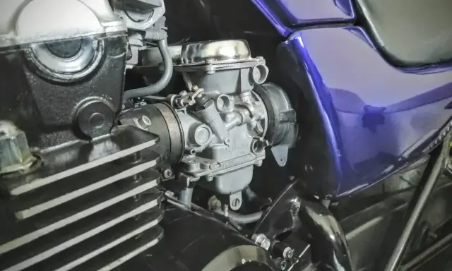 Silnik motocykla z gaźnikiem i fioletowym bakiem. Gotowy do dolotu i dalszej jazdy.