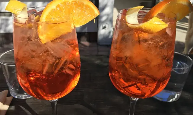 Dwa orzeźwiające drinki z pomarańczą i lodem. Idealne na aperitivo, co to jest? To włoska tradycja!