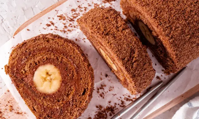 Pyszna rolada biszkoptowa z bananem w środku, posypana kakaową posypką. Idealna na deser.